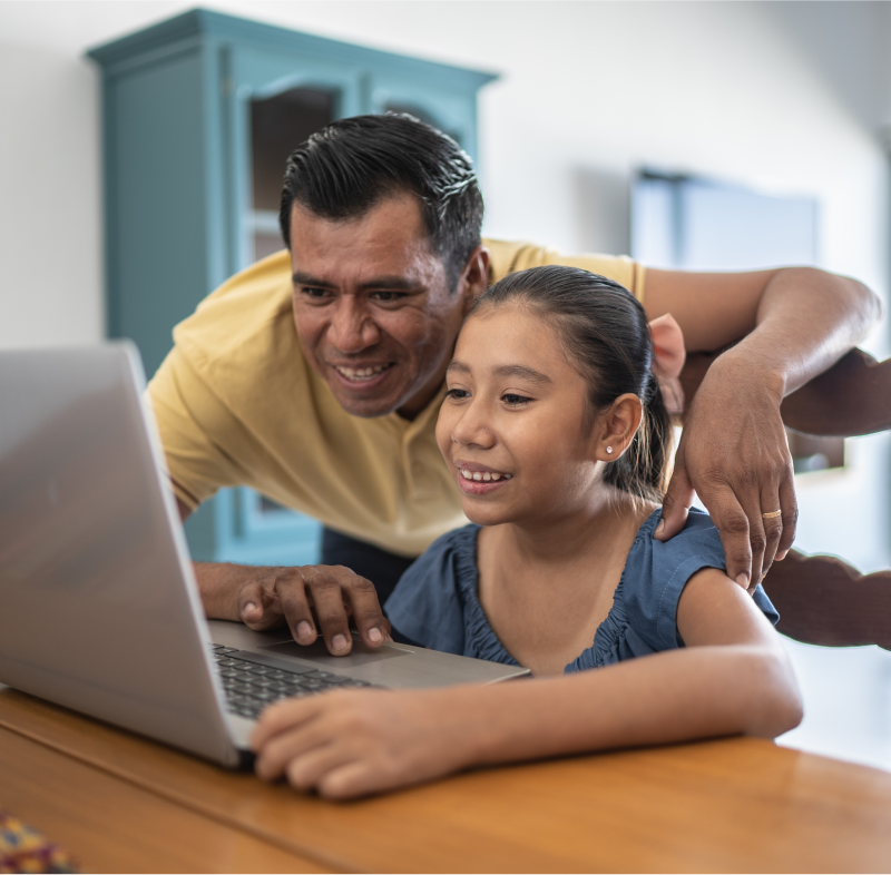 Padre e hija usando portatil