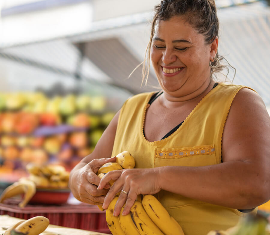 Mujer sonriendo sosteniendo bananos